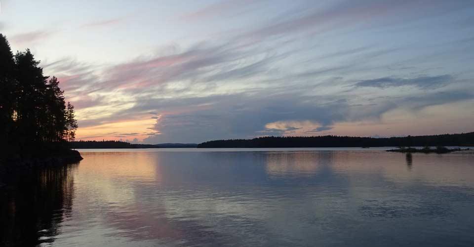 Kuva järvimaisemasta auringonlaskun aikaan.